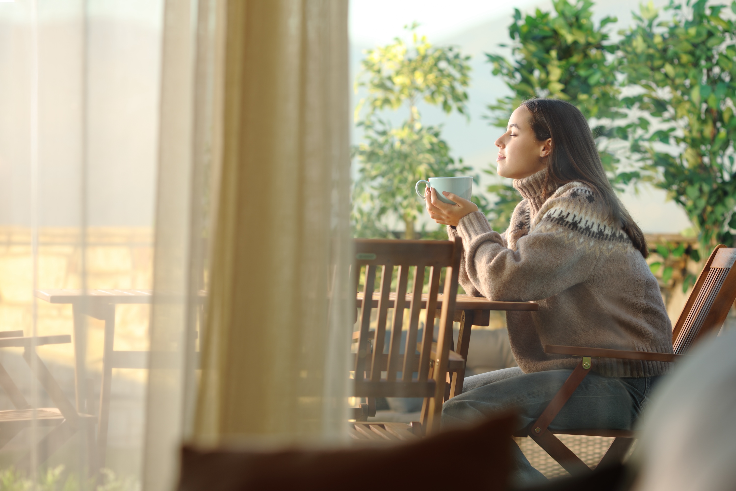 Resident relaxing with coffee on a sunlit patio at Wildcat Vista, Godley