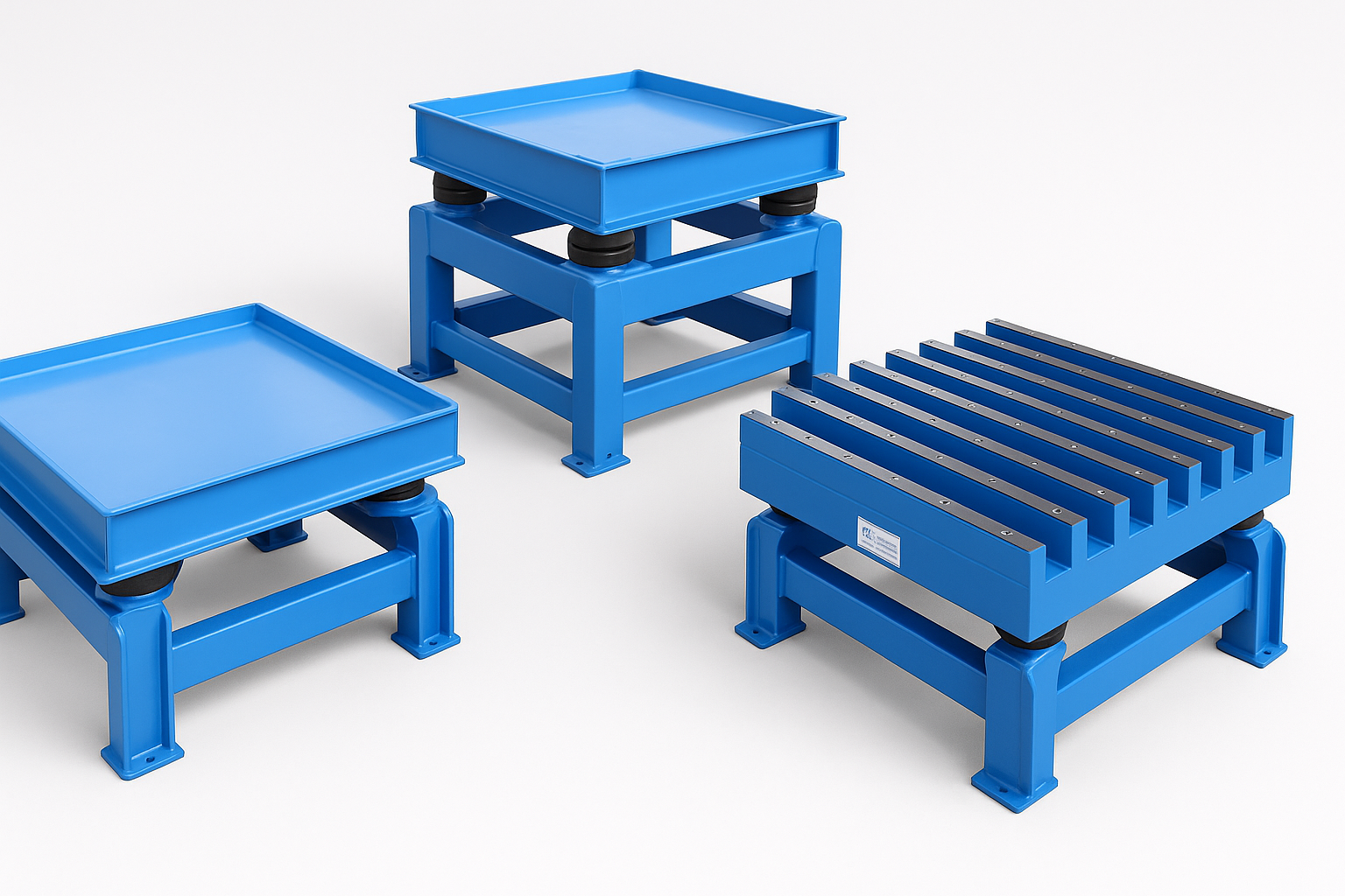 Three industrial-grade blue vibratory tables designed for bulk material handling: one flat deck model, one grid deck model, and one elevated grid deck table with isolators for vibration control.