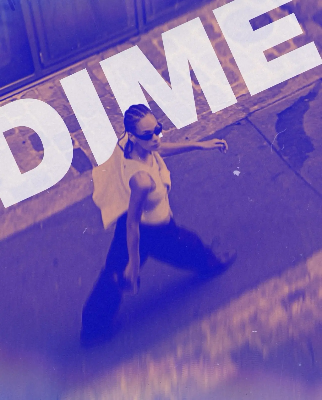 Bird's-eye DIME campaign still of a woman walking under tilted white typography