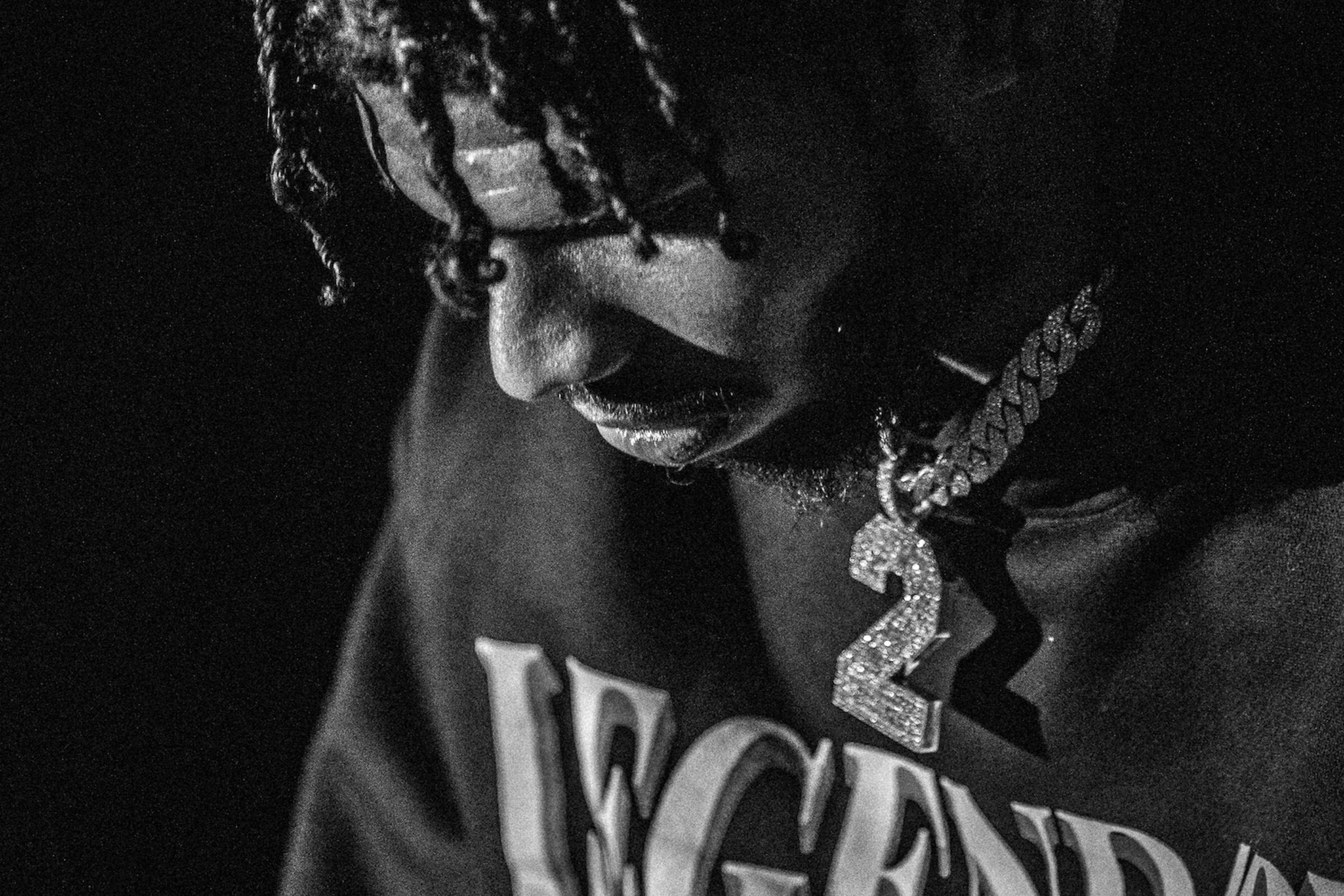 Grainy black-and-white close-up of Legendary campaign model with diamond number-2 pendant