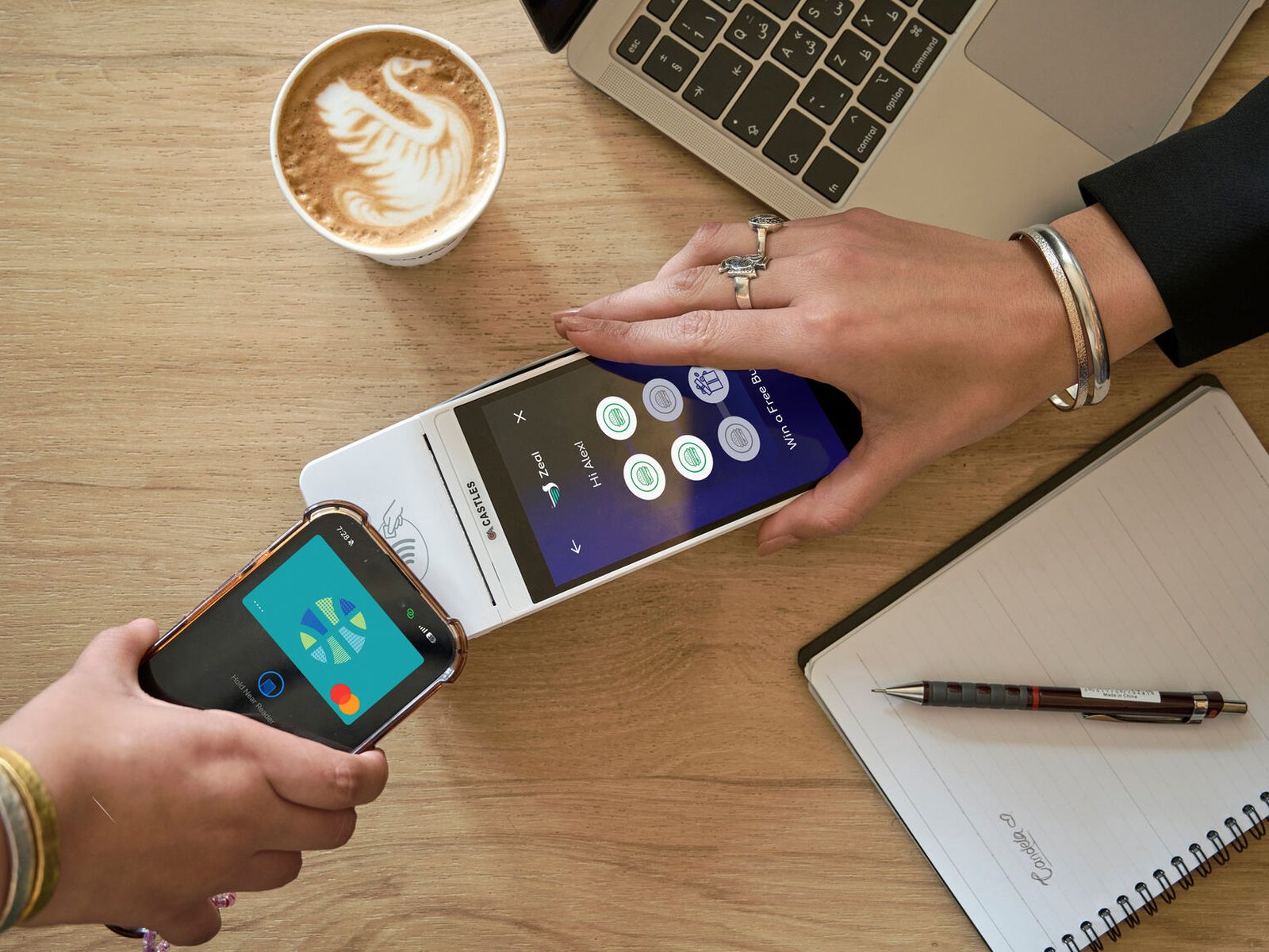 Phone tap payment terminal loyalty stamps coffee laptop desk overhead
