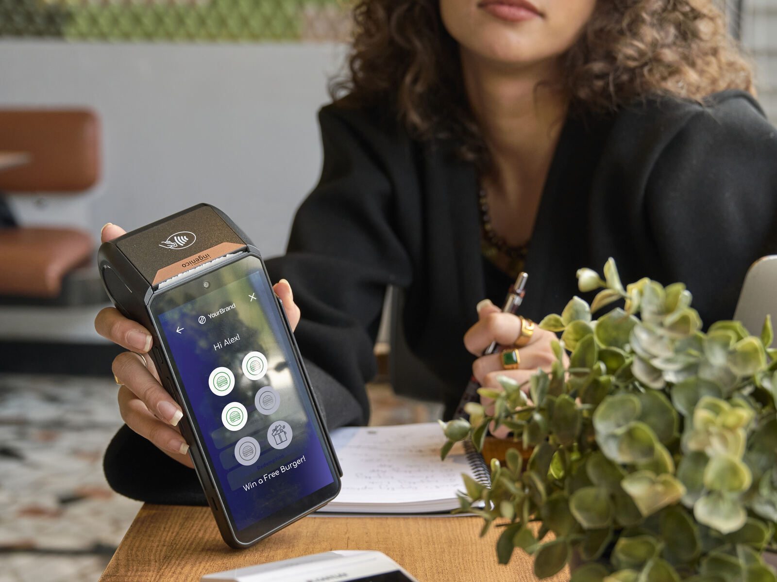 Hands using payment terminal home screen cafe table