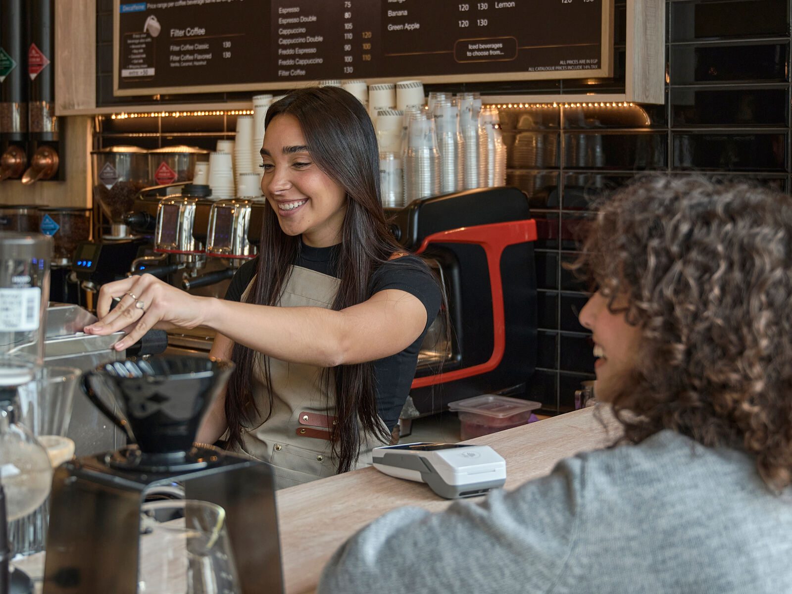 Barista serving customer cafe counter interior