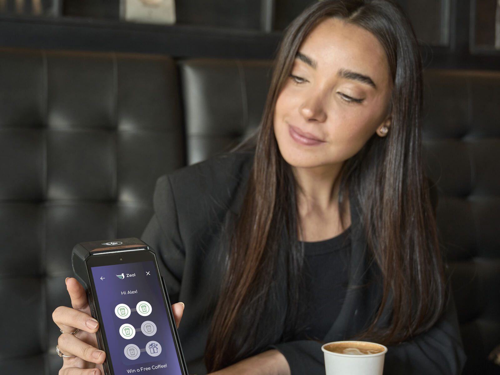 Woman holding payment terminal loyalty screen cafe booth coffee