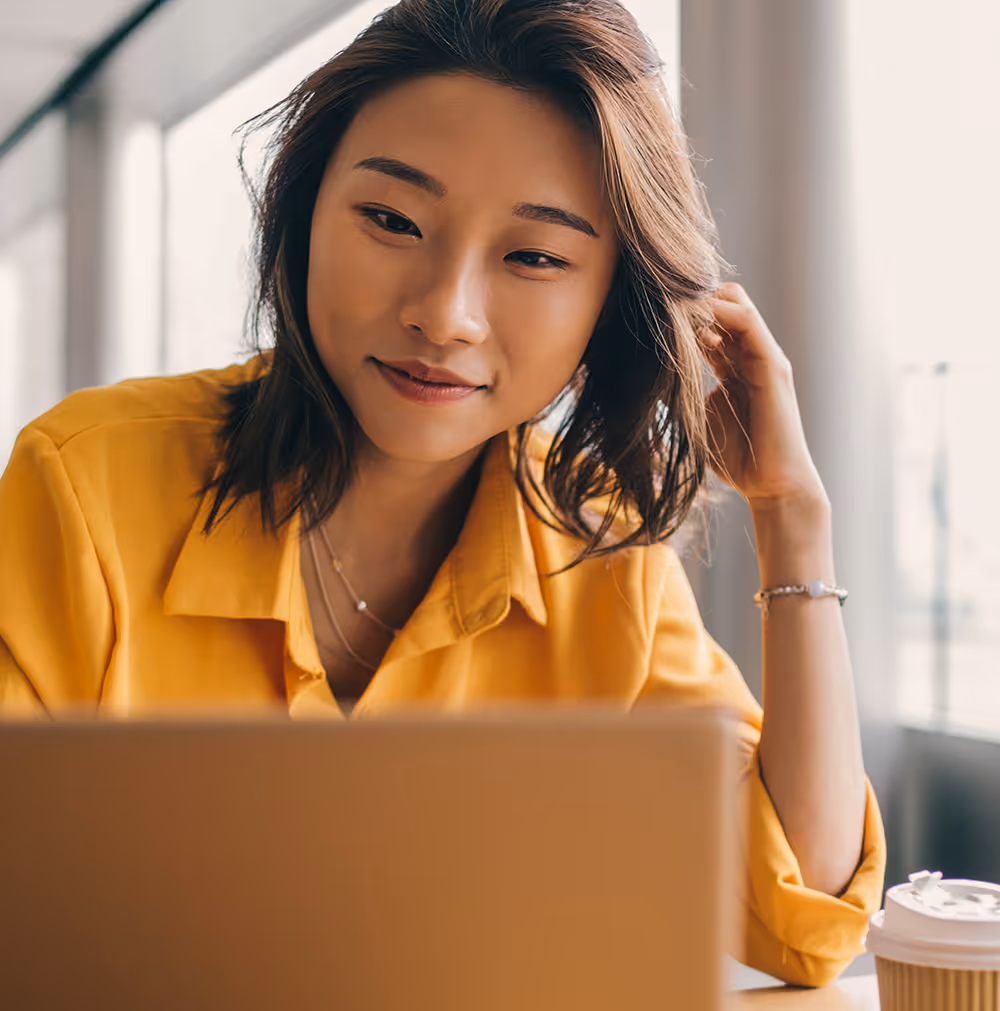 Young woman using a computer and drinking a coffee 