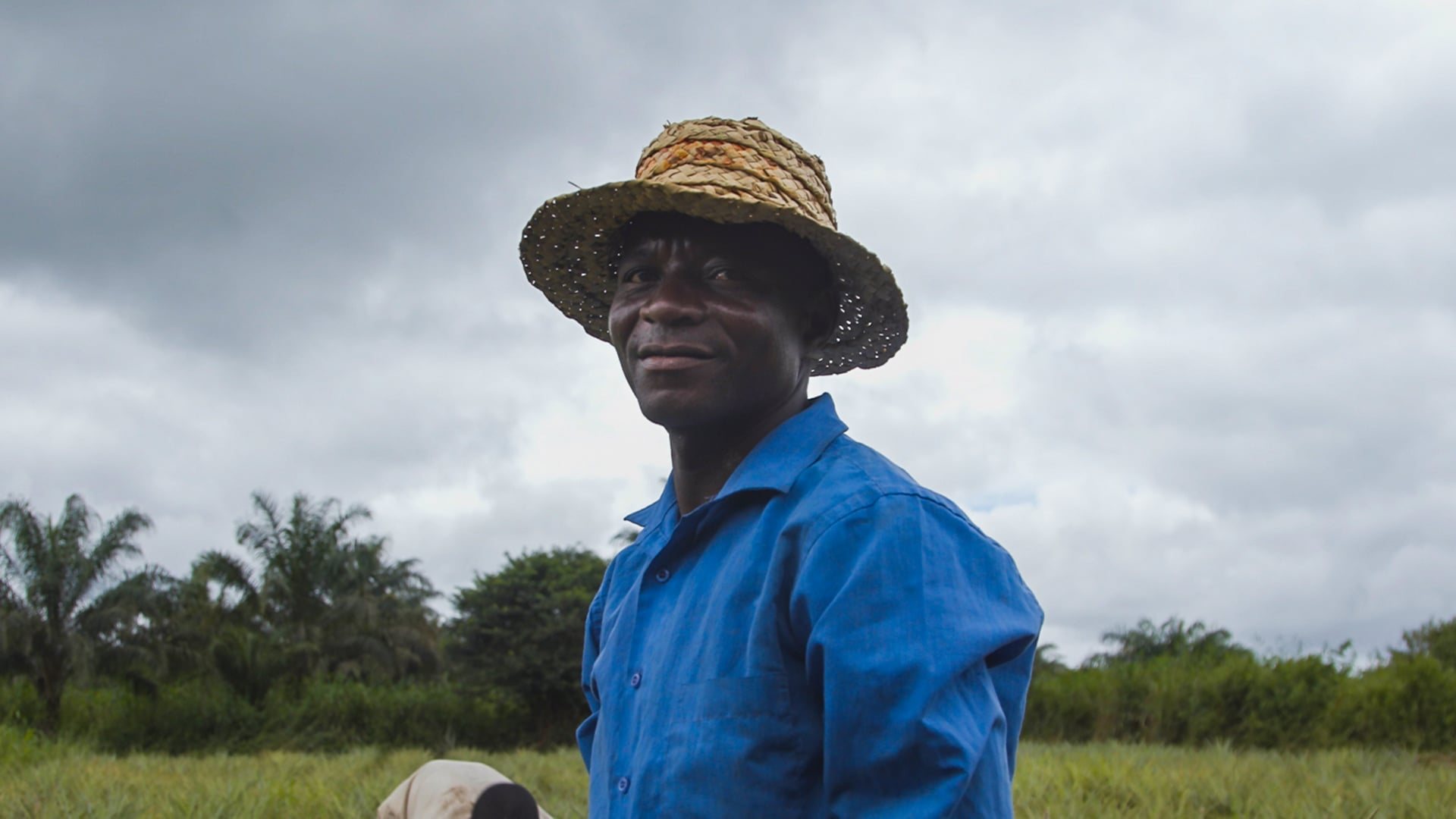 A farmer in a straw hat in the field