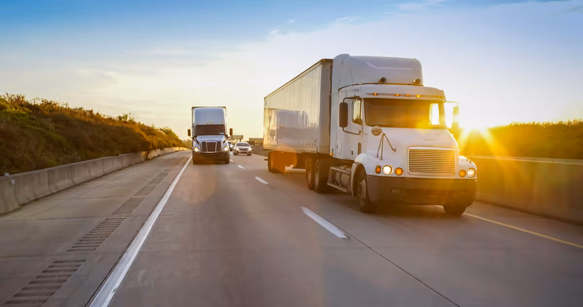 A few semi-trucks moving furniture cross-country on the highway.