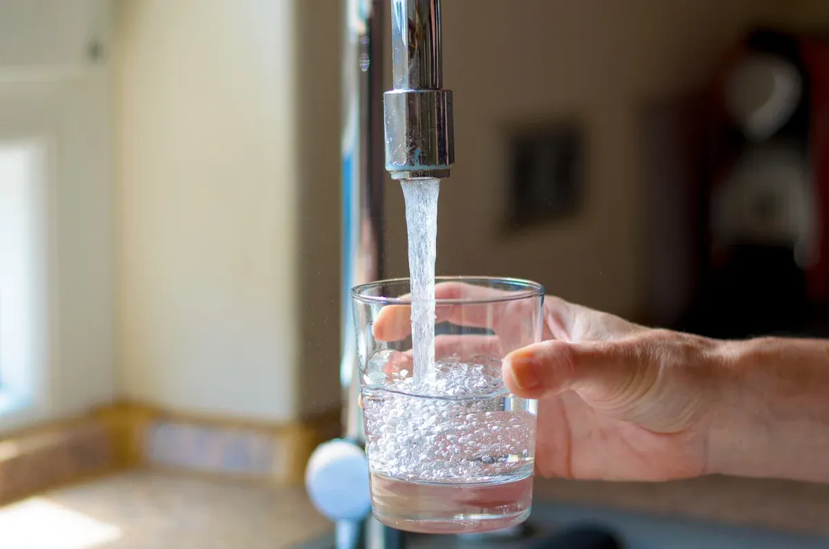 A person is filling a glass with water.