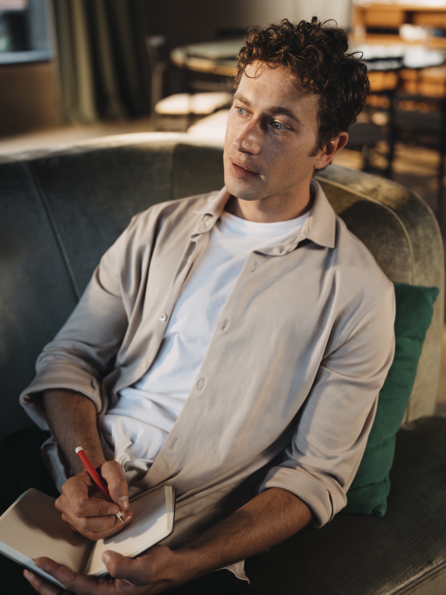 Man writing in a notebook wearing a Natural Dye Grey Chirimoya Pima cotton shirt.