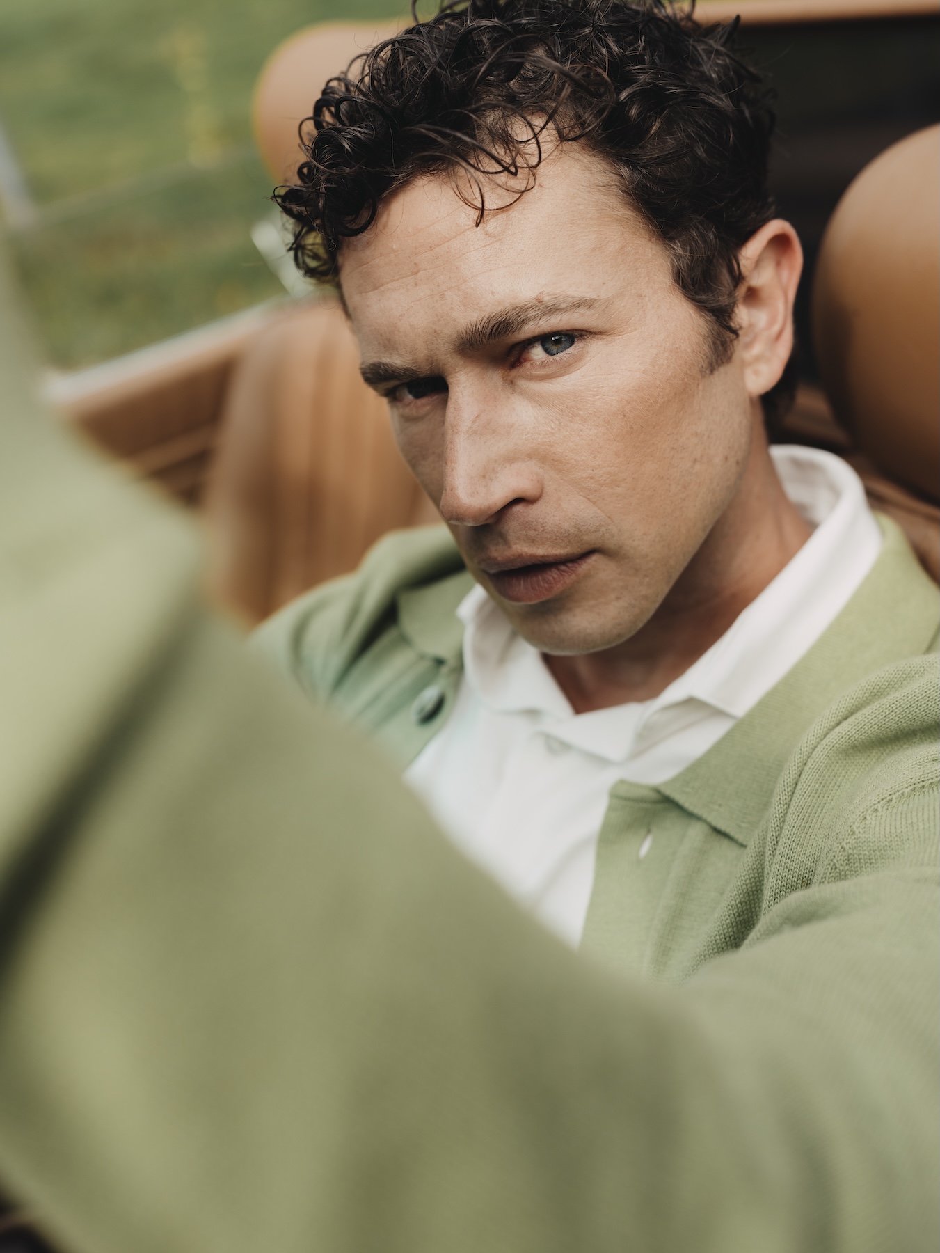 Close-up of man wearing a green Baby Pima cardigan and Pima dress shirt.