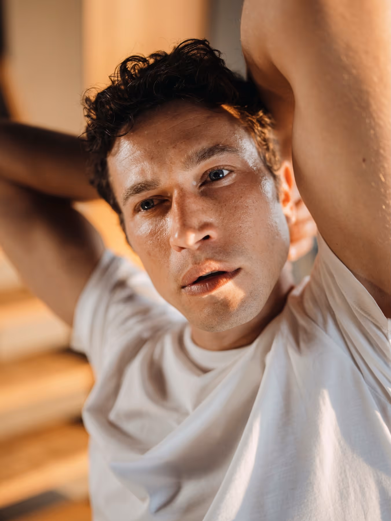 Man leaning back wearing a white Chirimoya Pima T-shirt.