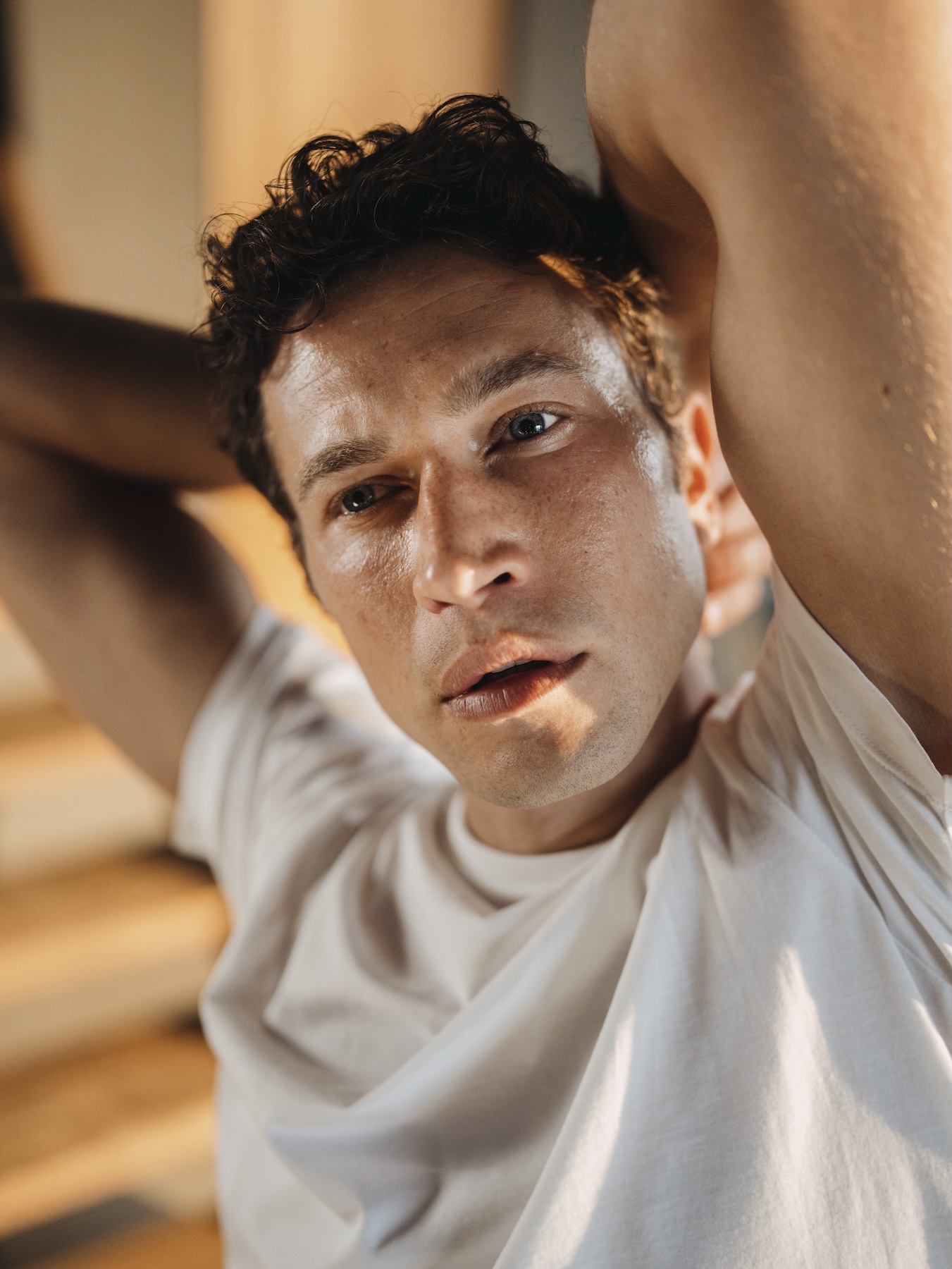 Man leaning back wearing a white Chirimoya Pima T-shirt.