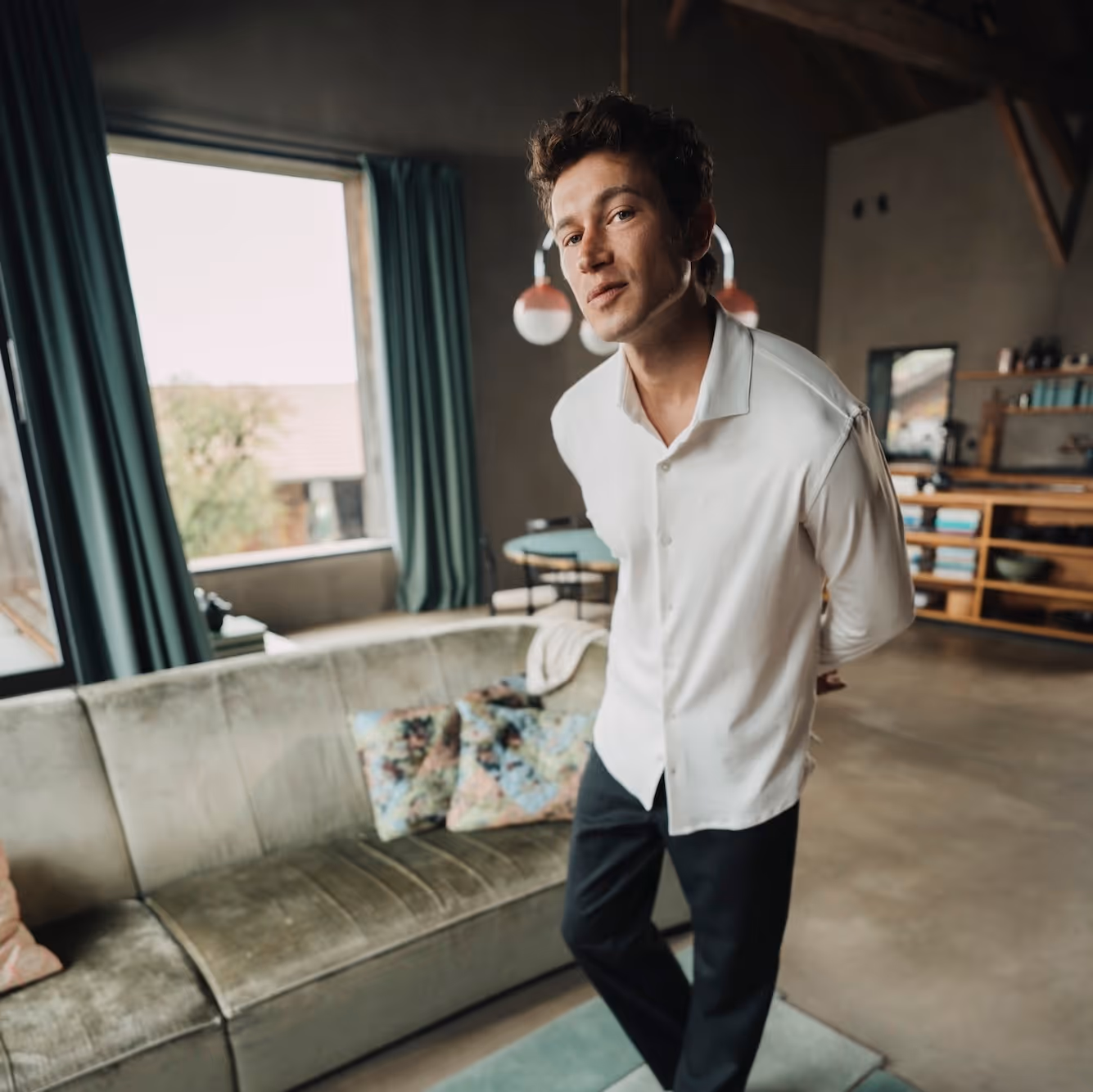 Man walking indoors wearing a white Chirimoya classic Pima T-shirt.