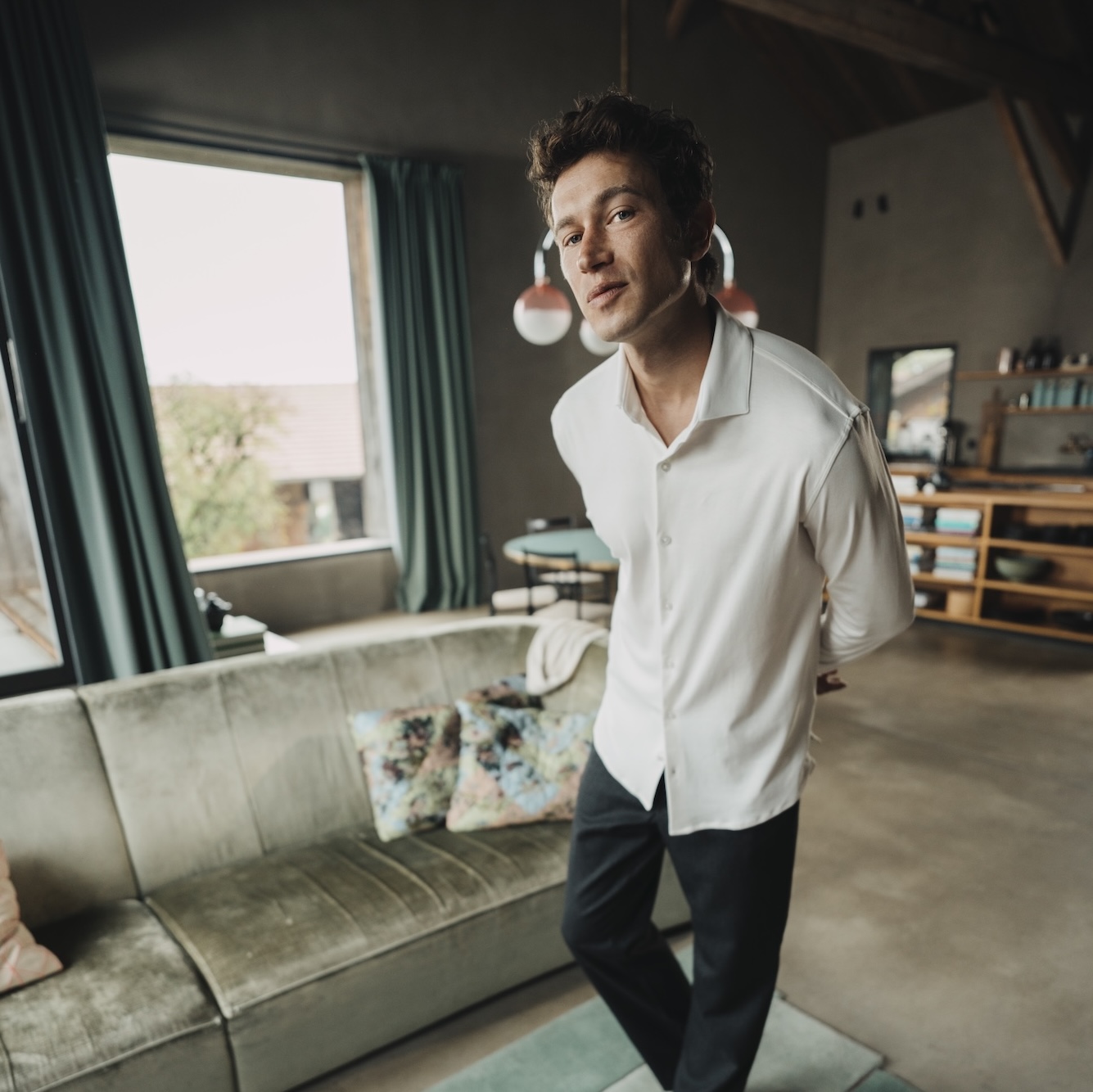 Man walking indoors wearing a white Chirimoya classic Pima T-shirt.