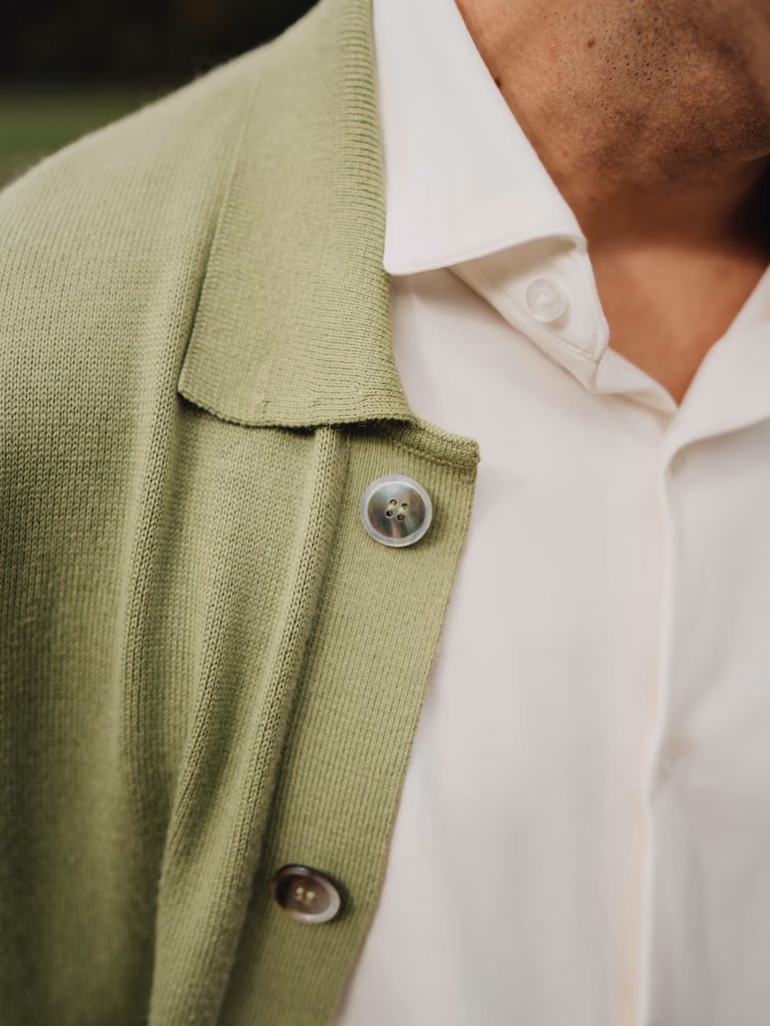 Close-up of Chirimoya’s baby pima cardigan layered over a white pima dress shirt, showing texture and buttons.