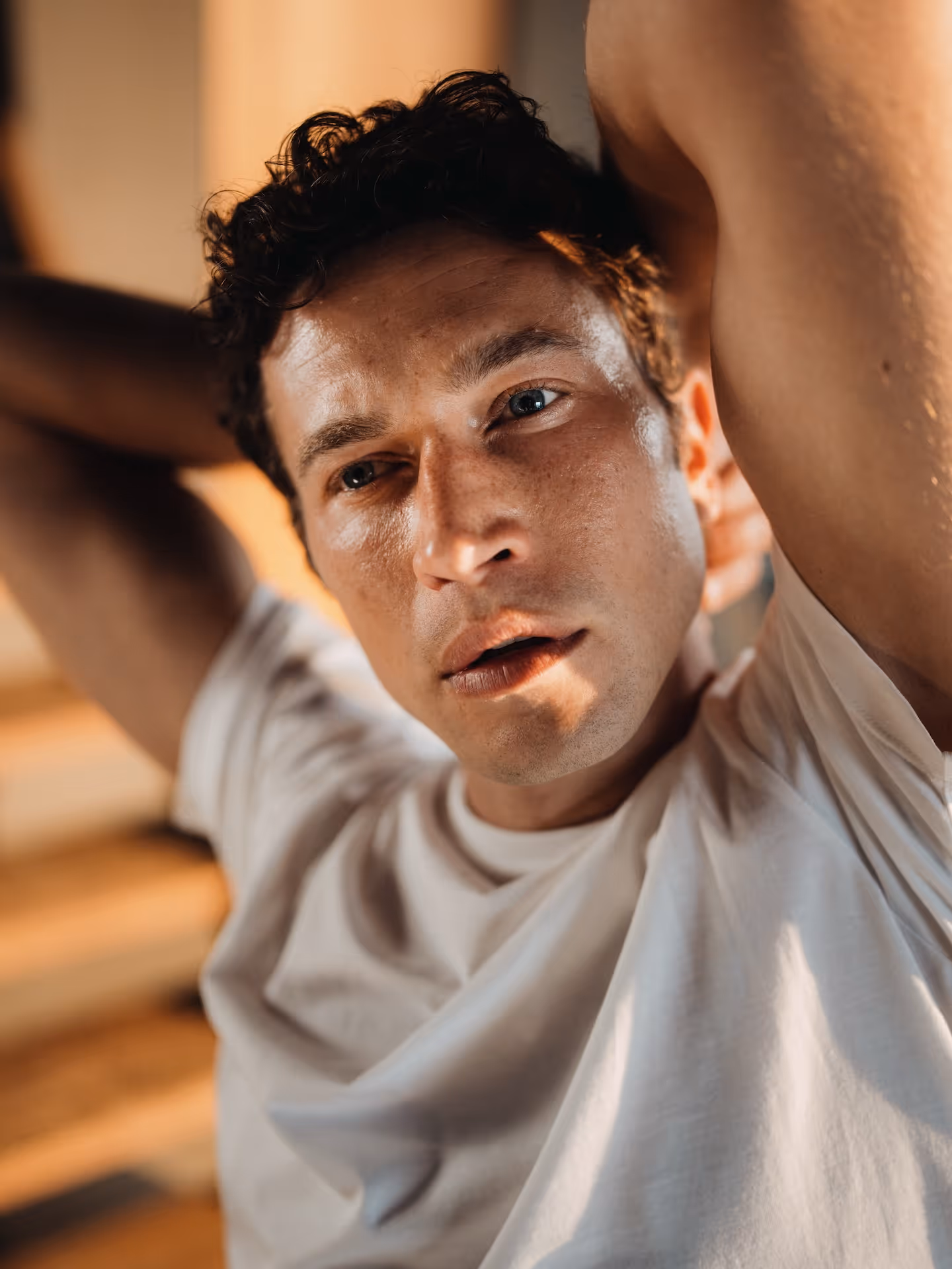 Close-up of man in warm light wearing a white Chirimoya Classic Pima cotton T-shirt.