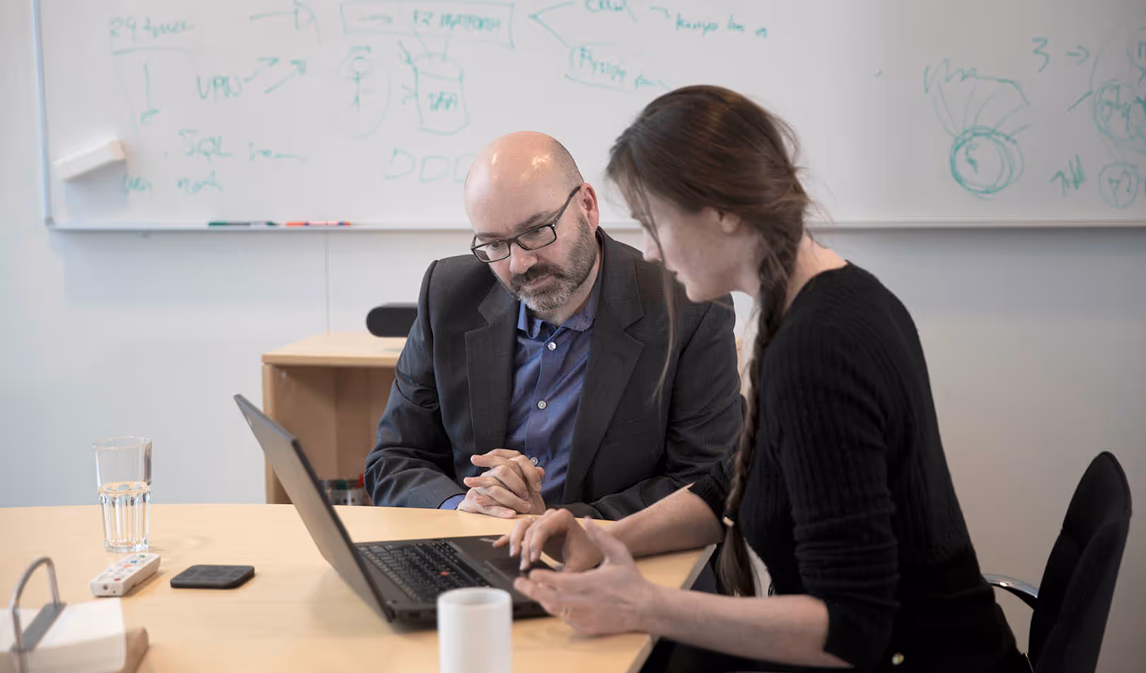 Two cBrain employees in front of a laptop