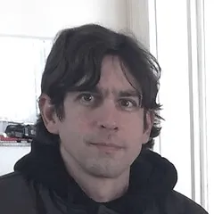Professional headshot photo of Adolfo Neto, Associate Professor and podcast creator specializing in Elixir