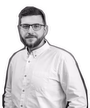 Bearded man with glasses wearing a light-colored button-up shirt on a transparent background.