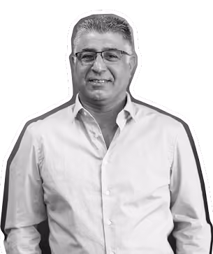 Middle-aged man with glasses wearing a light button-up shirt smiling at the camera.