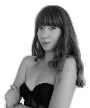 Black and white photo of a woman with long hair, bangs, and a strapless top, posing confident.