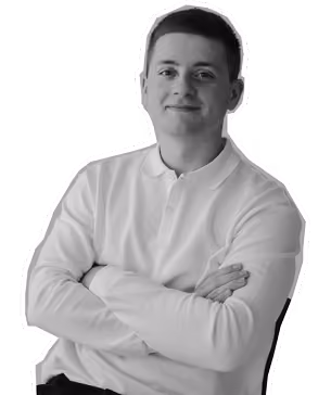 Smiling young man with short hair wearing a light-colored polo shirt, arms crossed.