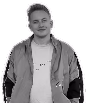 Smiling young man wearing a jacket over a white Nike Air shirt, facing the camera.