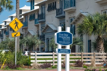 Peach colored condos in Florida with a pedestrian sign out front