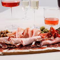 Plateau de charcuterie et vins assortis pour un apéritif traiteur élégant.