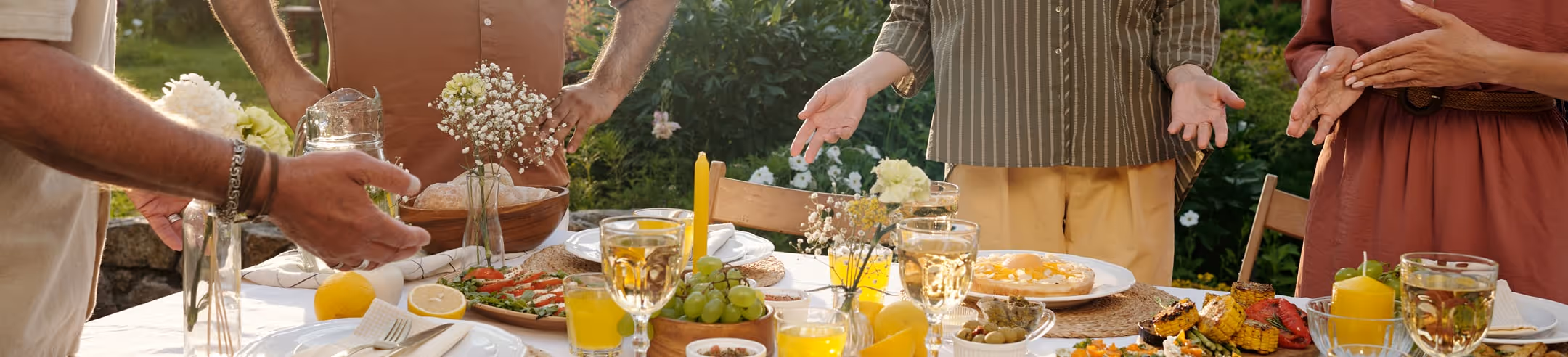 Repas de ripaille en extérieur, longue table festive entourée de convives dans un cadre verdoyant.