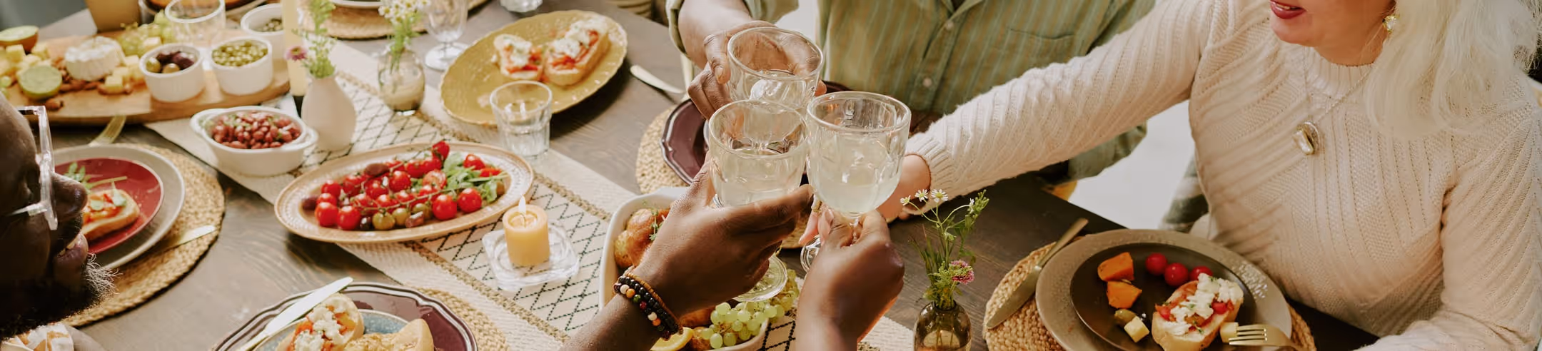 Repas convivial pour particuliers, table dressée avec des plats traiteur variés et appétissants.
