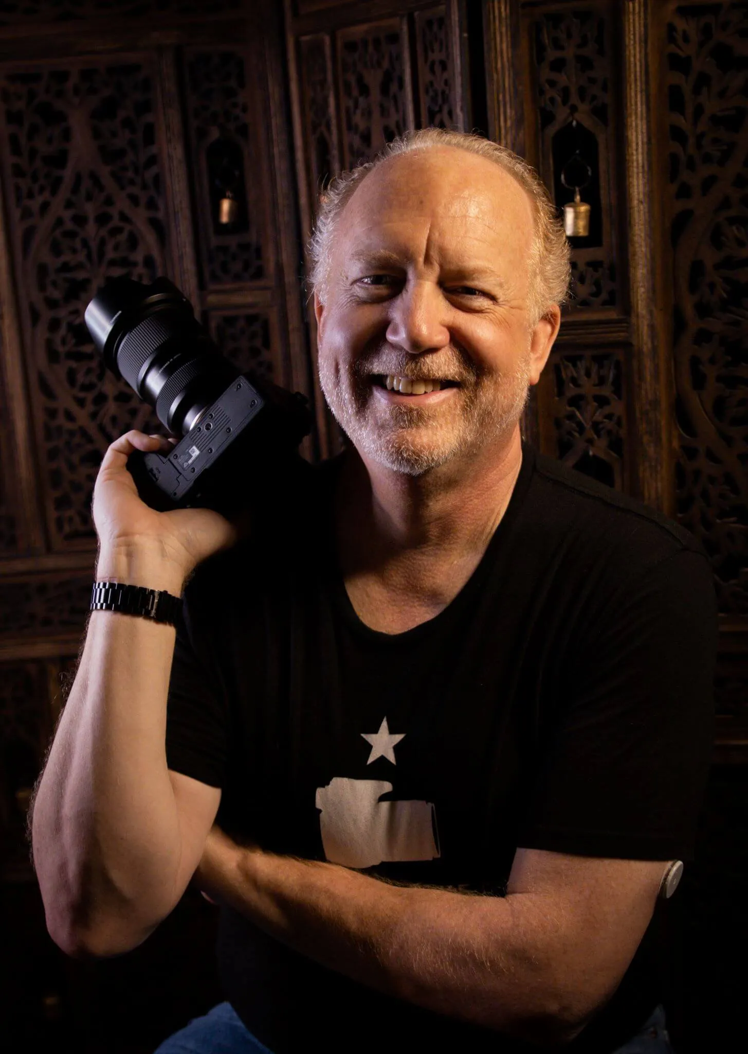 Allan Pickering, photographer of Steamy Esteem Boudoir, posing with camera and smiling. 