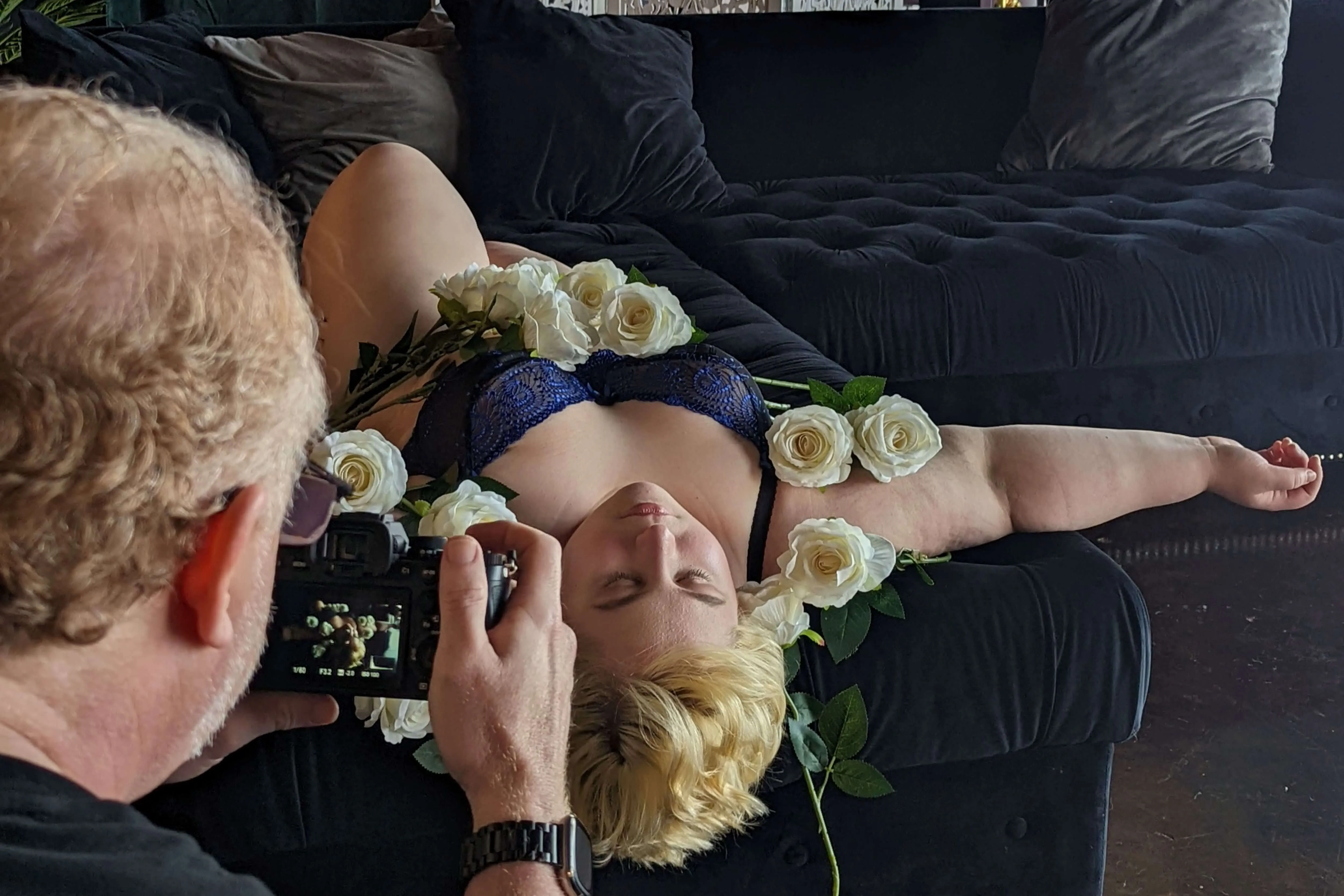 Allan Pickering of Steamy Esteem Boudoir taking photos of a blonde. plus sized woman in blue lingerie. 
