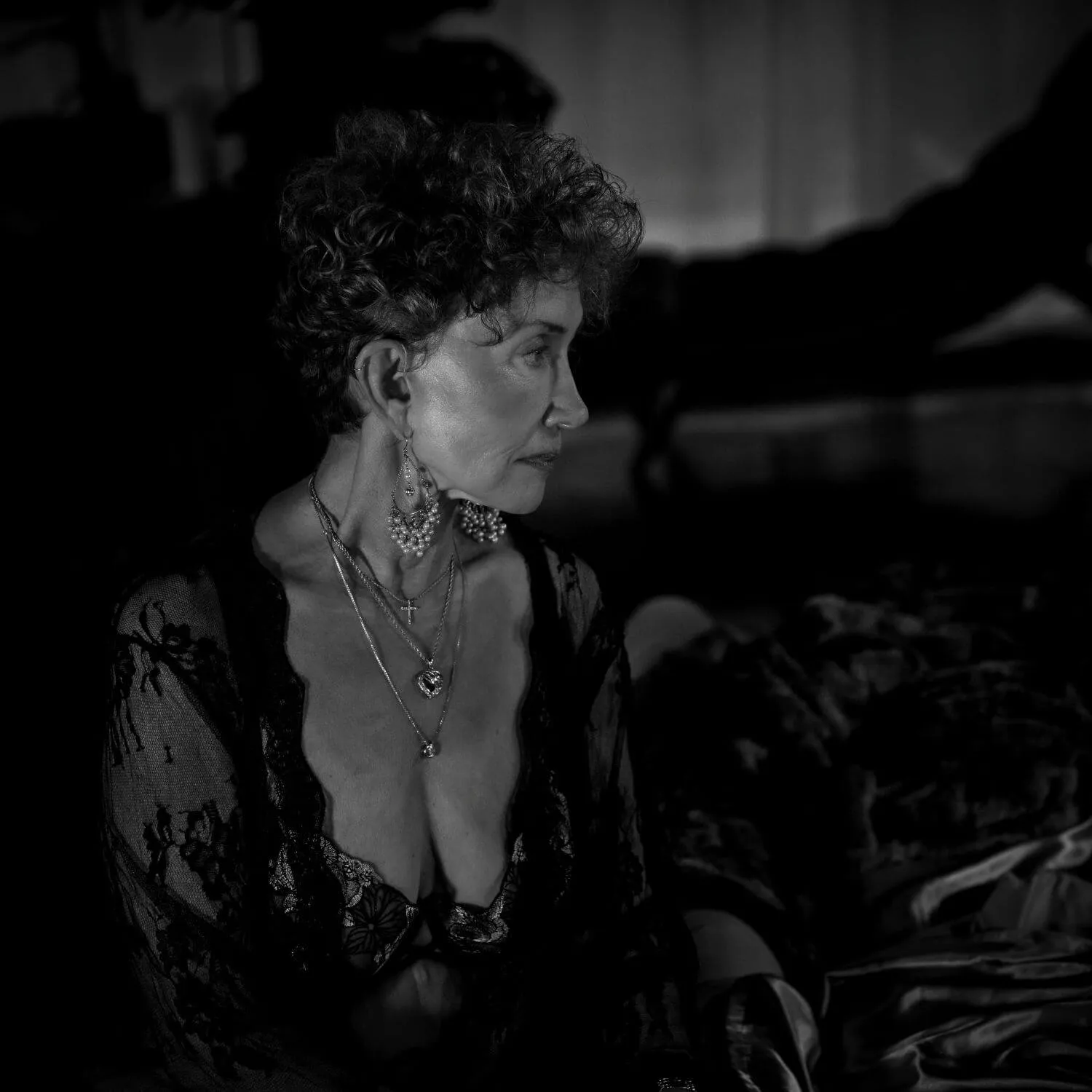 Confident senior in black sheer lingerie, staring off camera. 