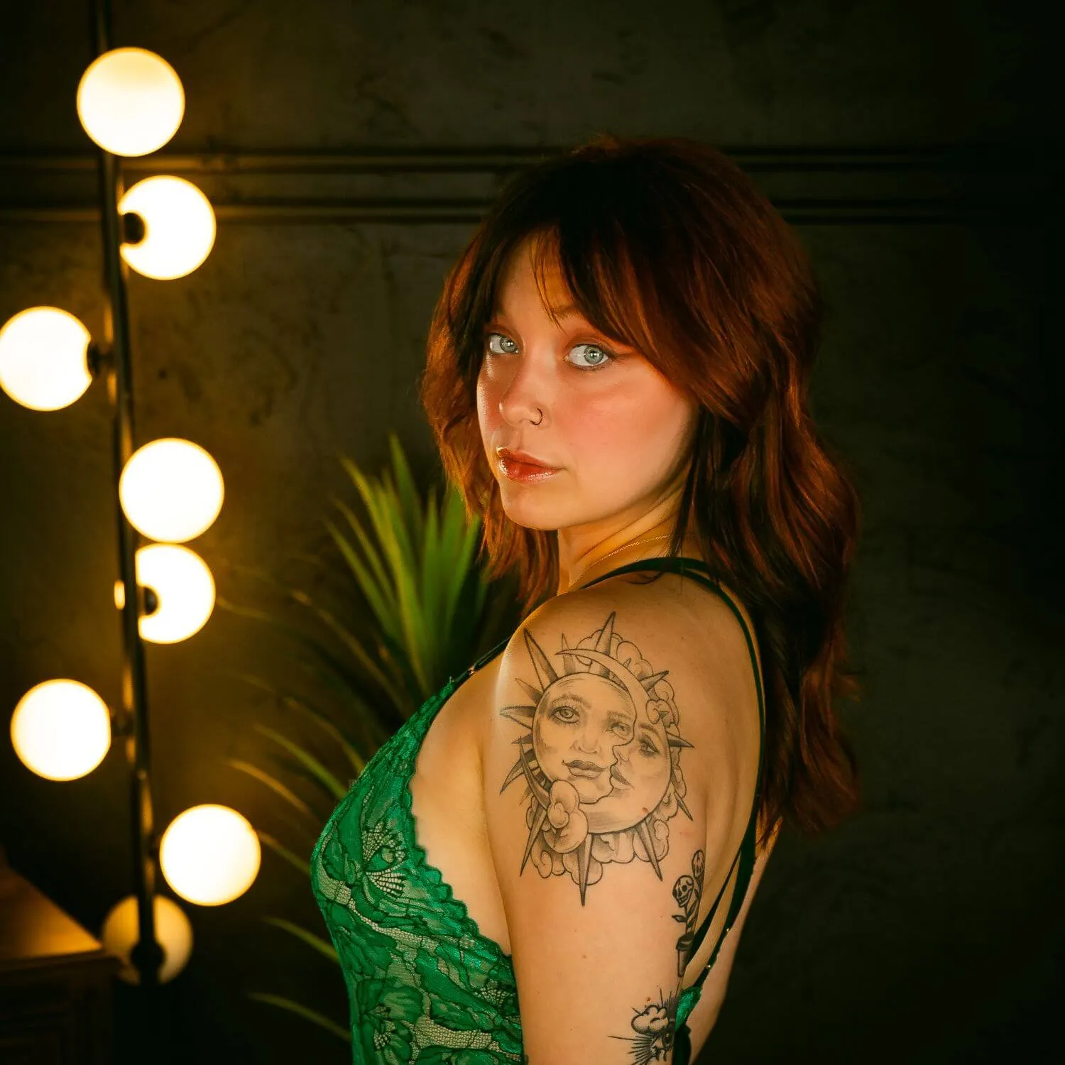 Redhead in green lingerie looking over shoulder confidently. 