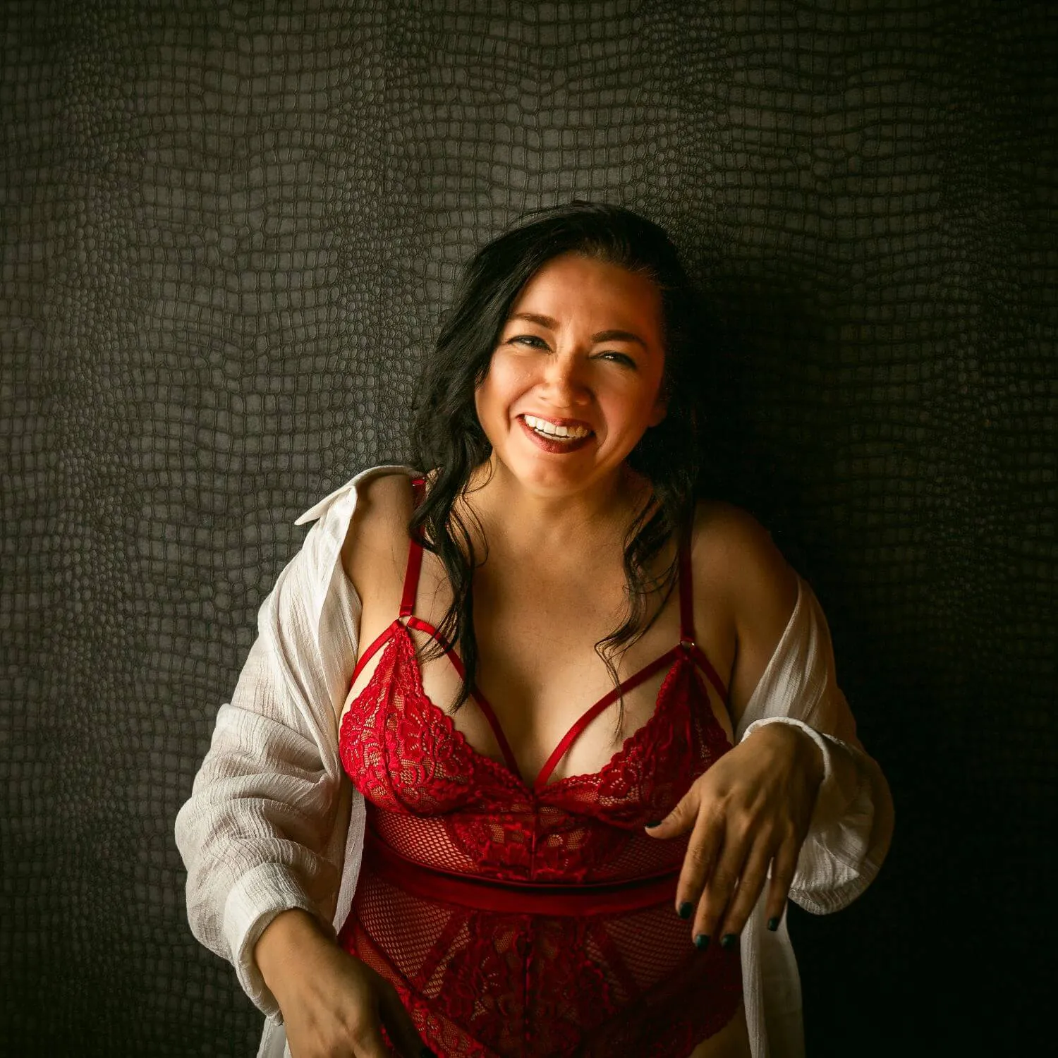 Happy woman, smiling, wearing unbuttoned white shirt and red lingerie.
