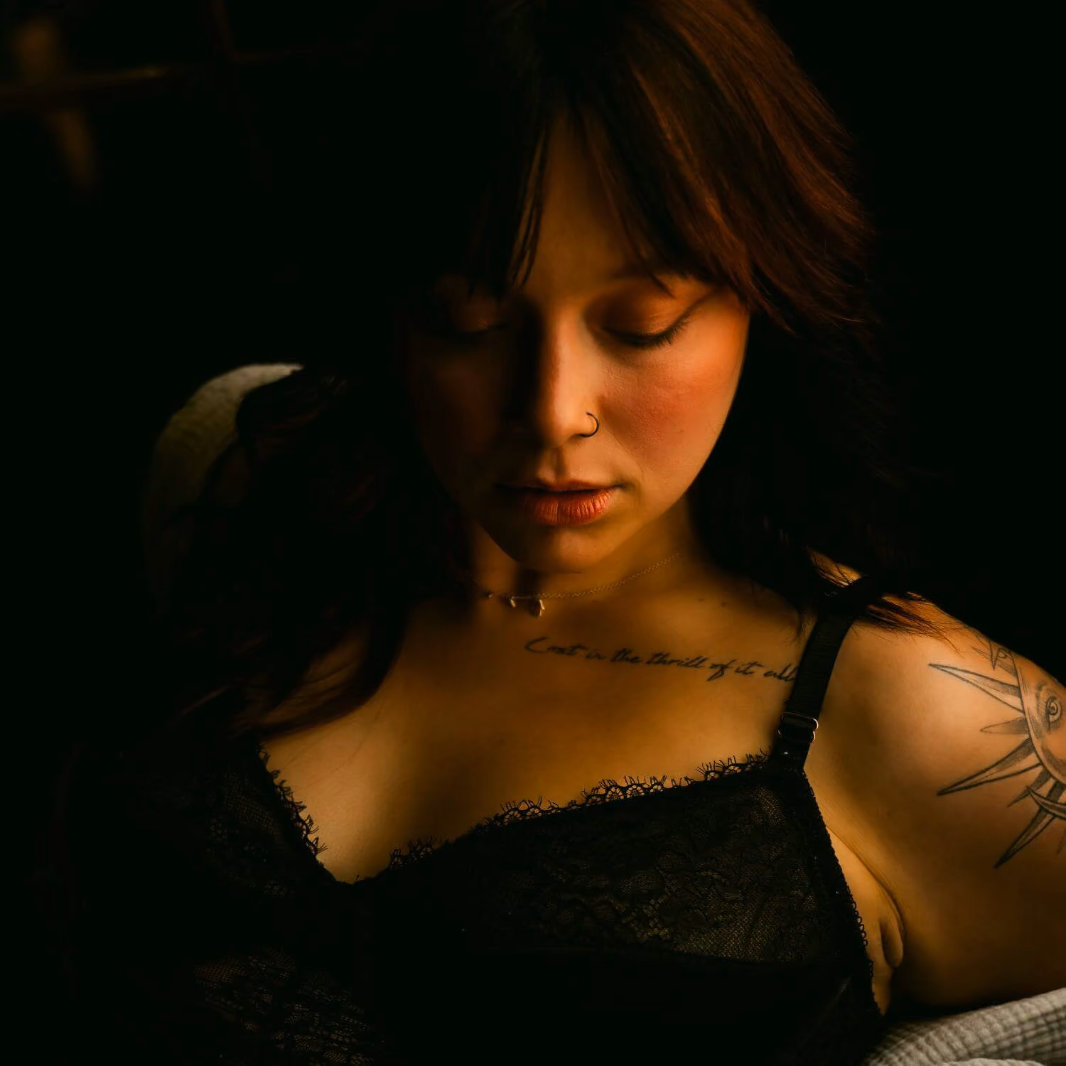 Woman's face, boudoir make-up, eyes closed, in black lingerie.
