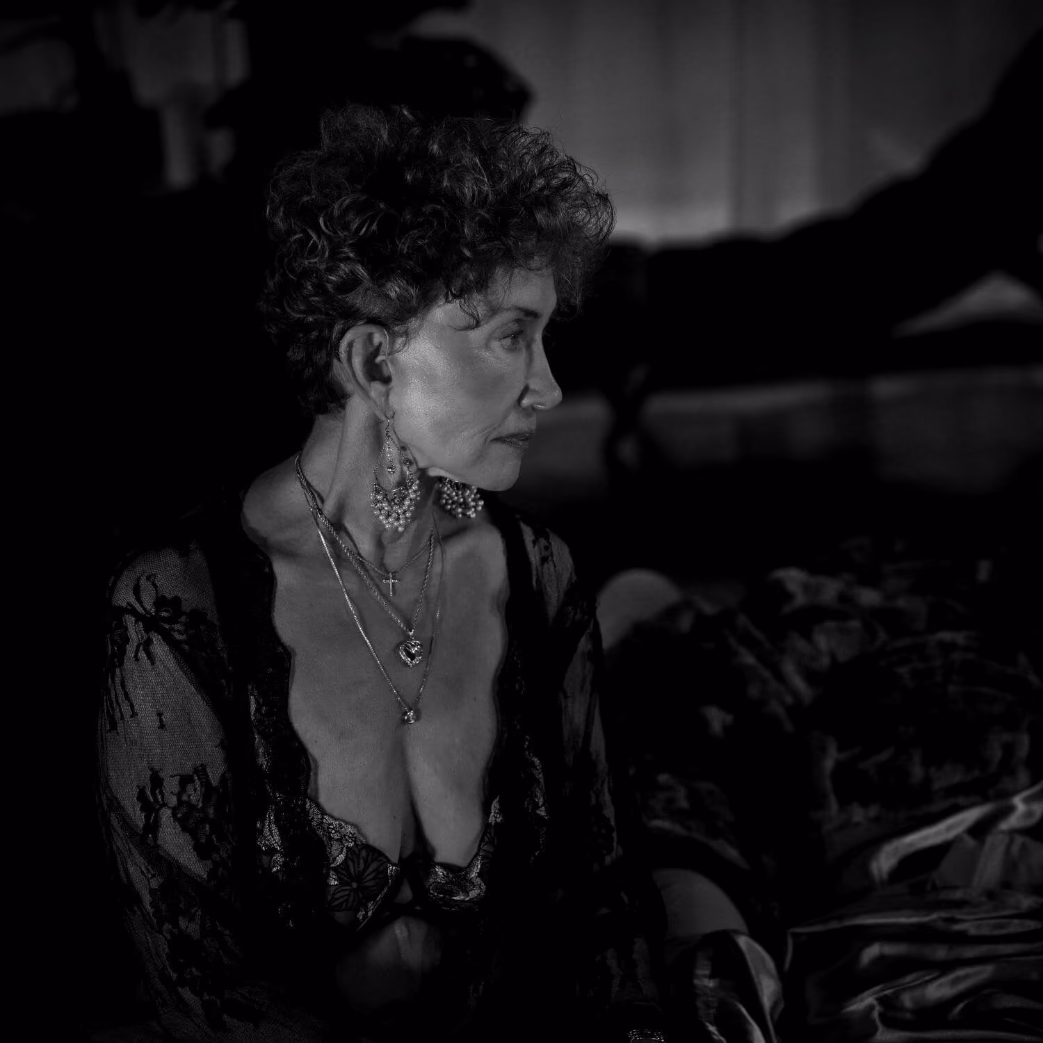 Confident senior in black sheer lingerie, staring off camera.