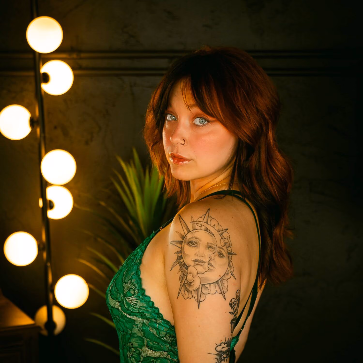 Redhead in green lingerie looking over shoulder confidently.