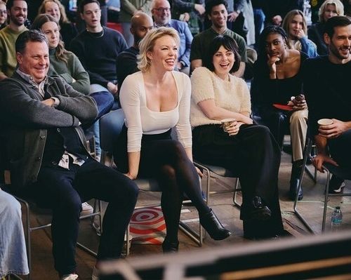 Color photo of Brooks Ashmanskas, Robyn Hurder, Krysta Rodriguez, and John Behlmann sitting in the front row of the company on the first day of rehearsal.