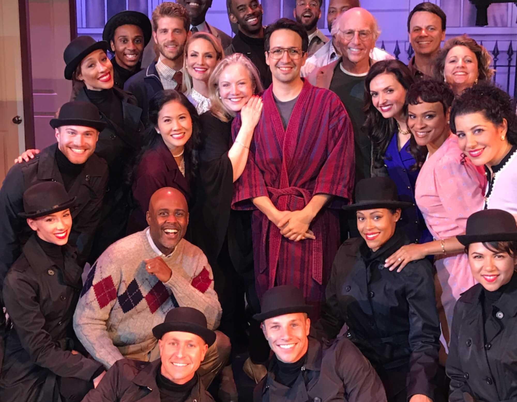 Group of people onstage in costume - Susan Stroman, Lin-Manuel Miranda, Larry David in the center surrounded by ~12 actors in the company of "Fatwa!" on set.