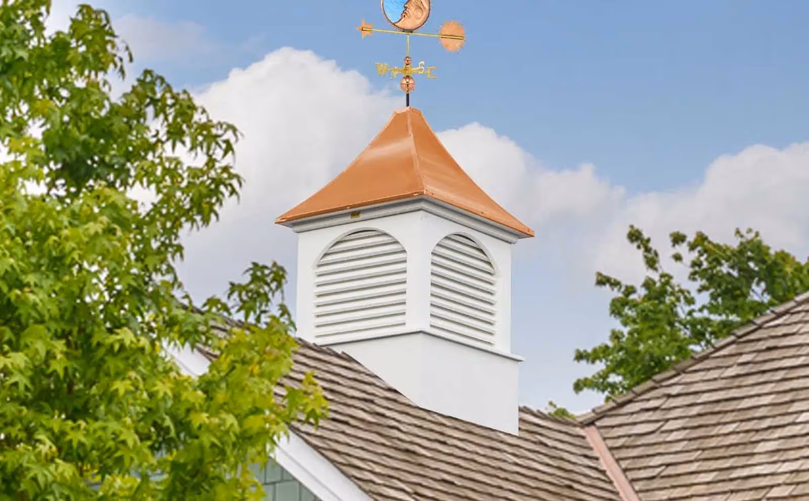 Estate Dalton cupola with wide arched louvers and a copper roof topped with a celestial weathervane, handcrafted by Twin Oaks Barns in Millersburg, OH.