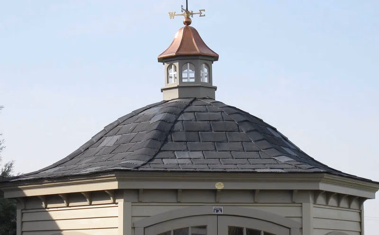 Copper-roofed gazebo cupola with cross-panel windows atop a slate-shingled roof, showcasing the Estate Gazebo Villa model.