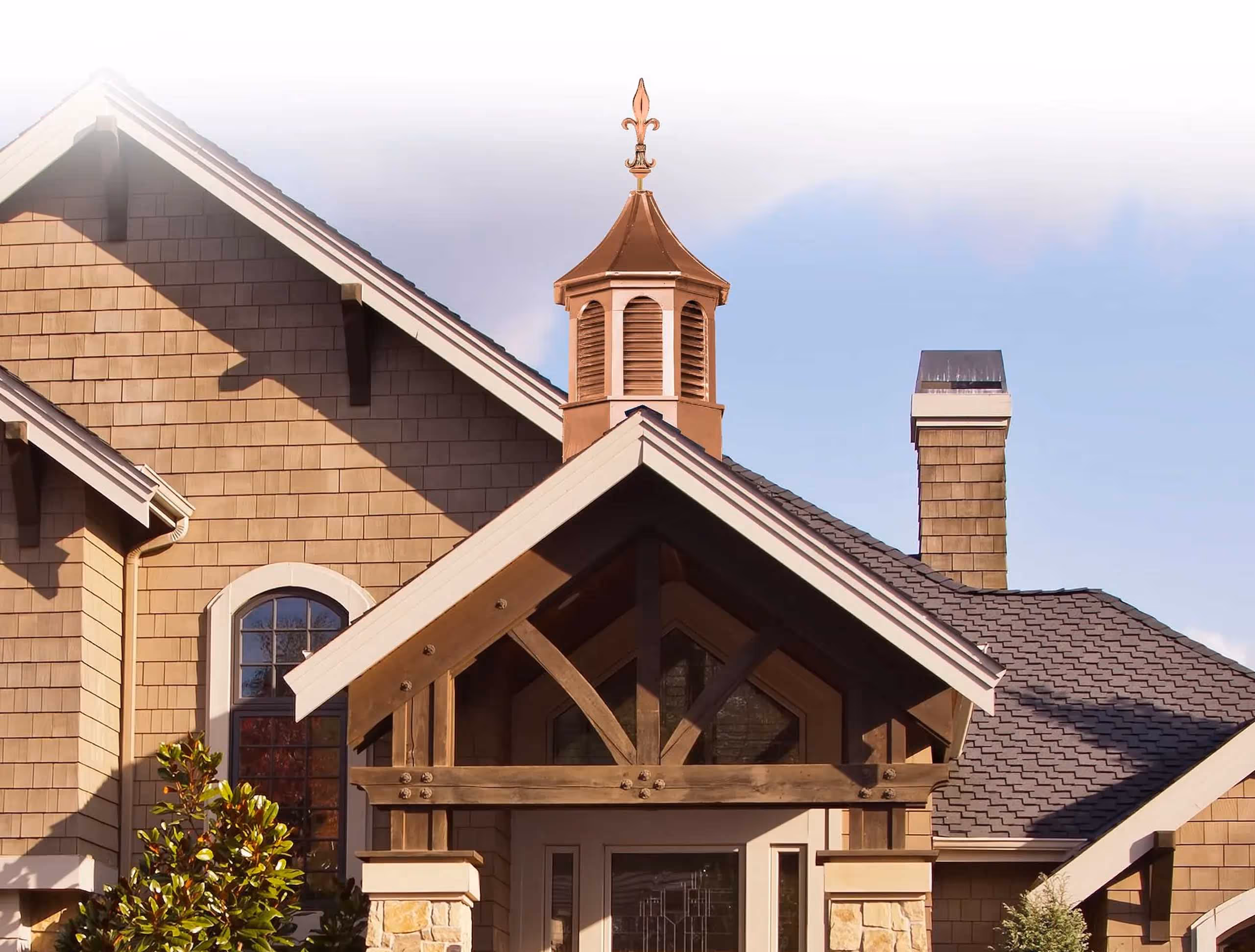 Copper-topped Kingston cupola with louvered sides and ornamental finial on a craftsman-style home, built by Twin Oaks Barns in Millersburg, Ohio.