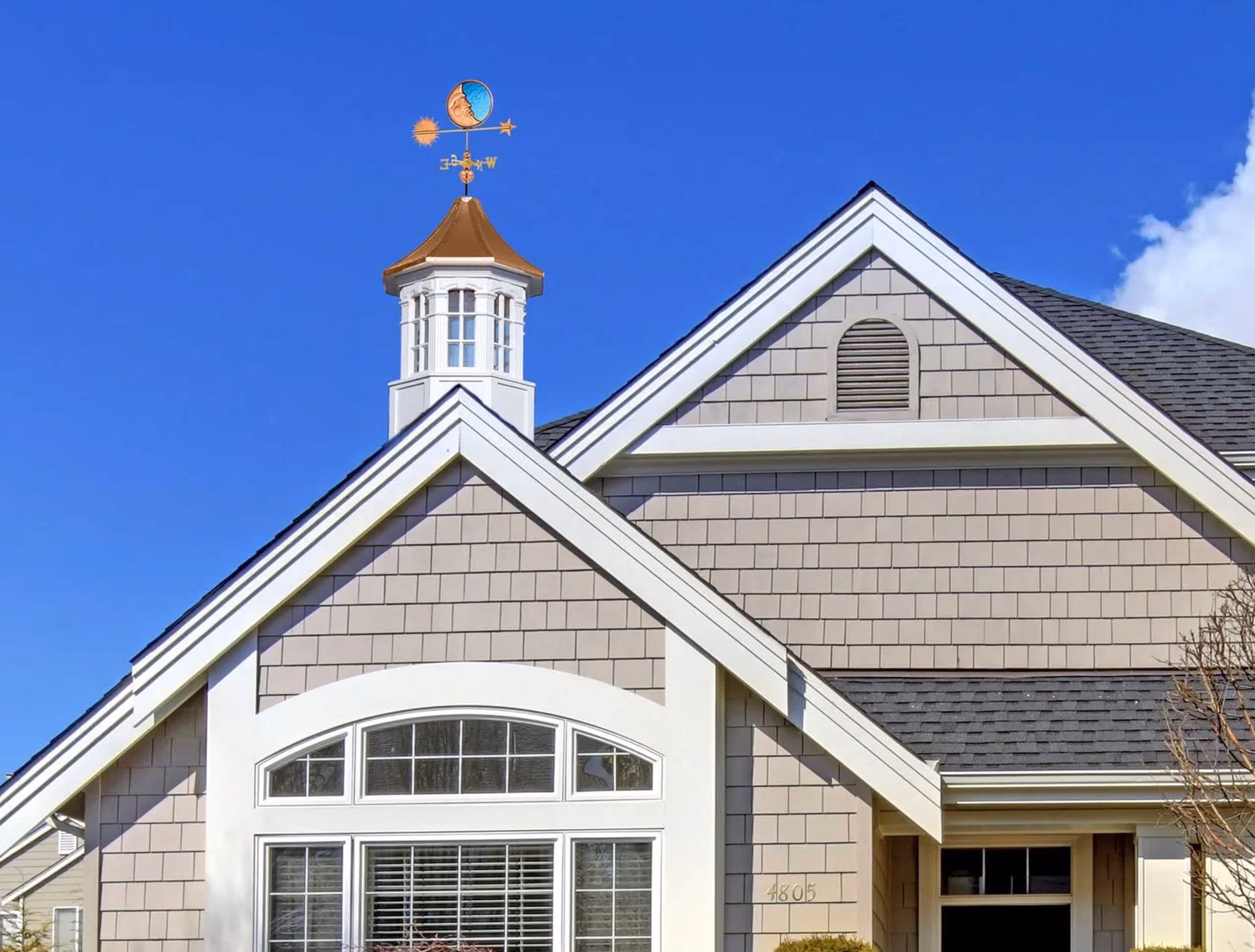 Danbury signature cupola featuring white arched louvers, detailed trim, and a brilliant copper spire, crafted in Millersburg, Ohio.