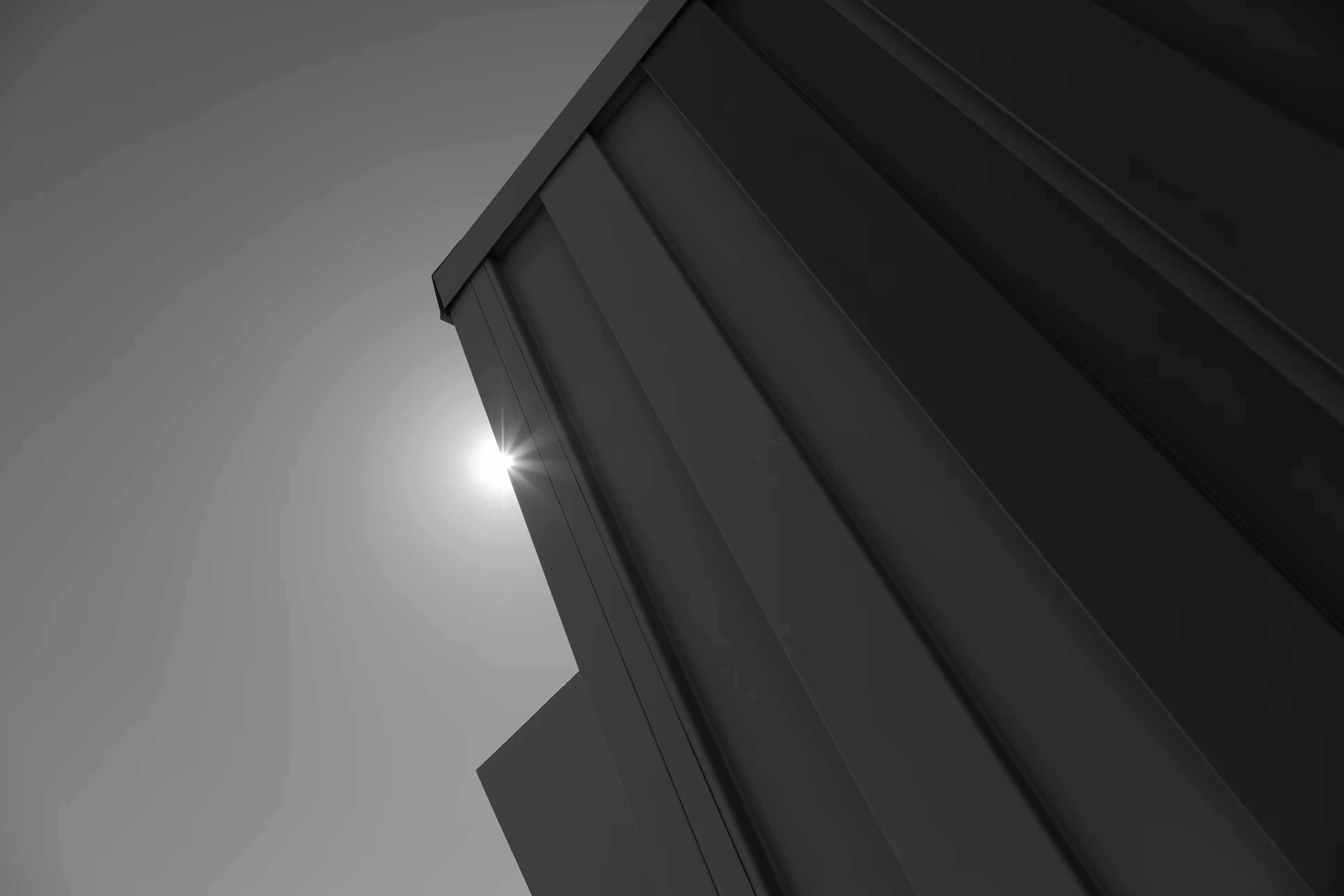 Low-angle roof facade of Reset Hotel with geometric design glowing in desert sun, Twentynine Palms