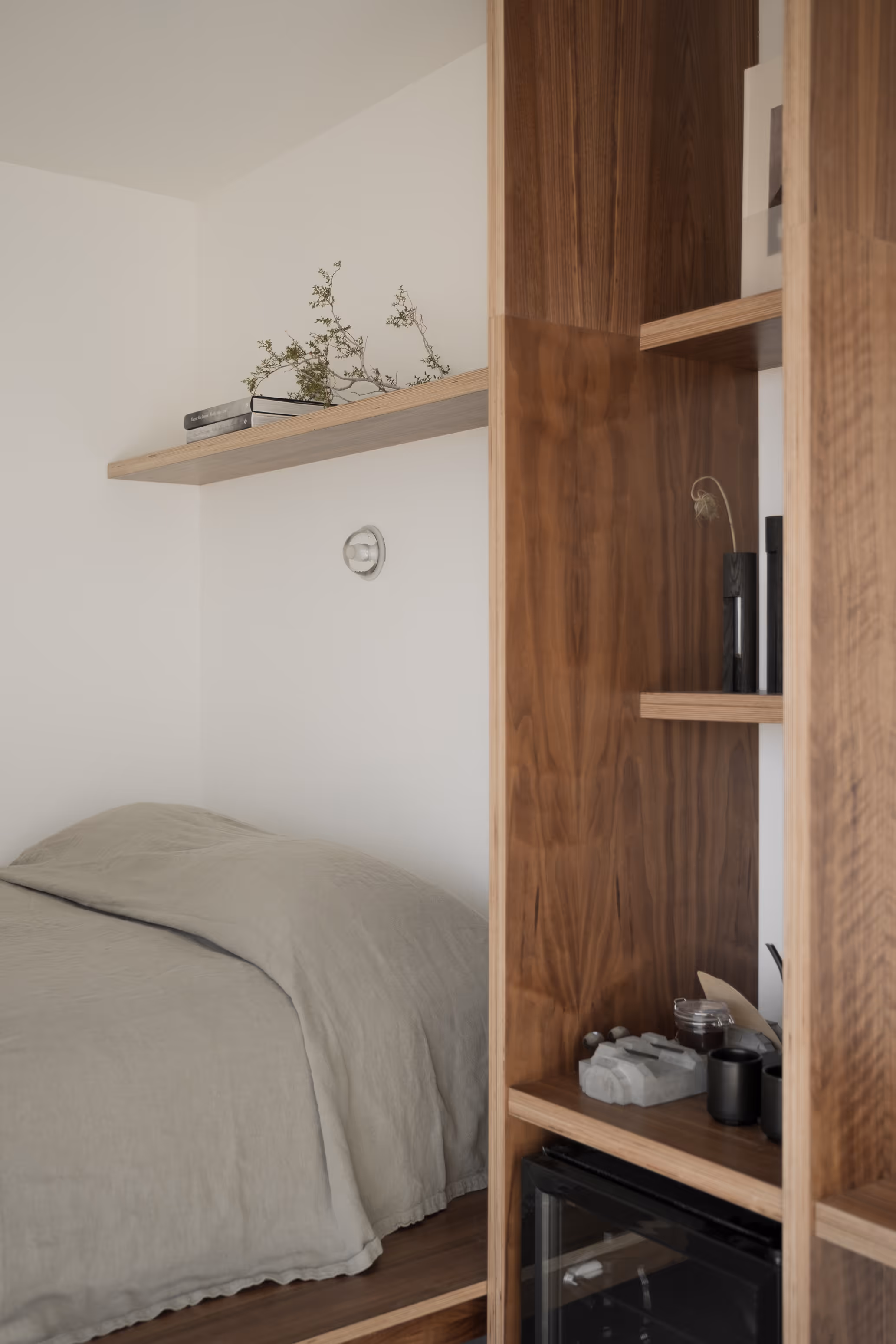 Minimalist bedroom at Reset Hotel, Twentynine Palms, with wooden shelving and neutral bed