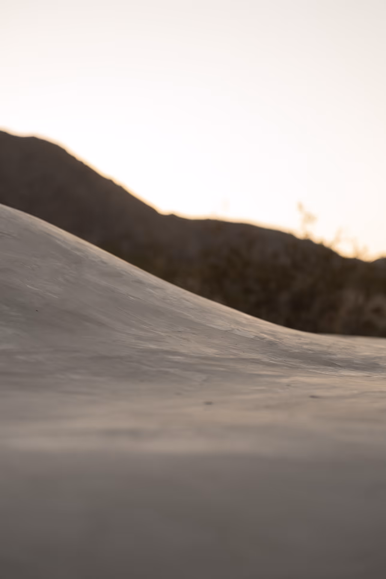 Sunset lights a sand dune near mountains at Twentynine Palms, perfect Reset Hotel view.