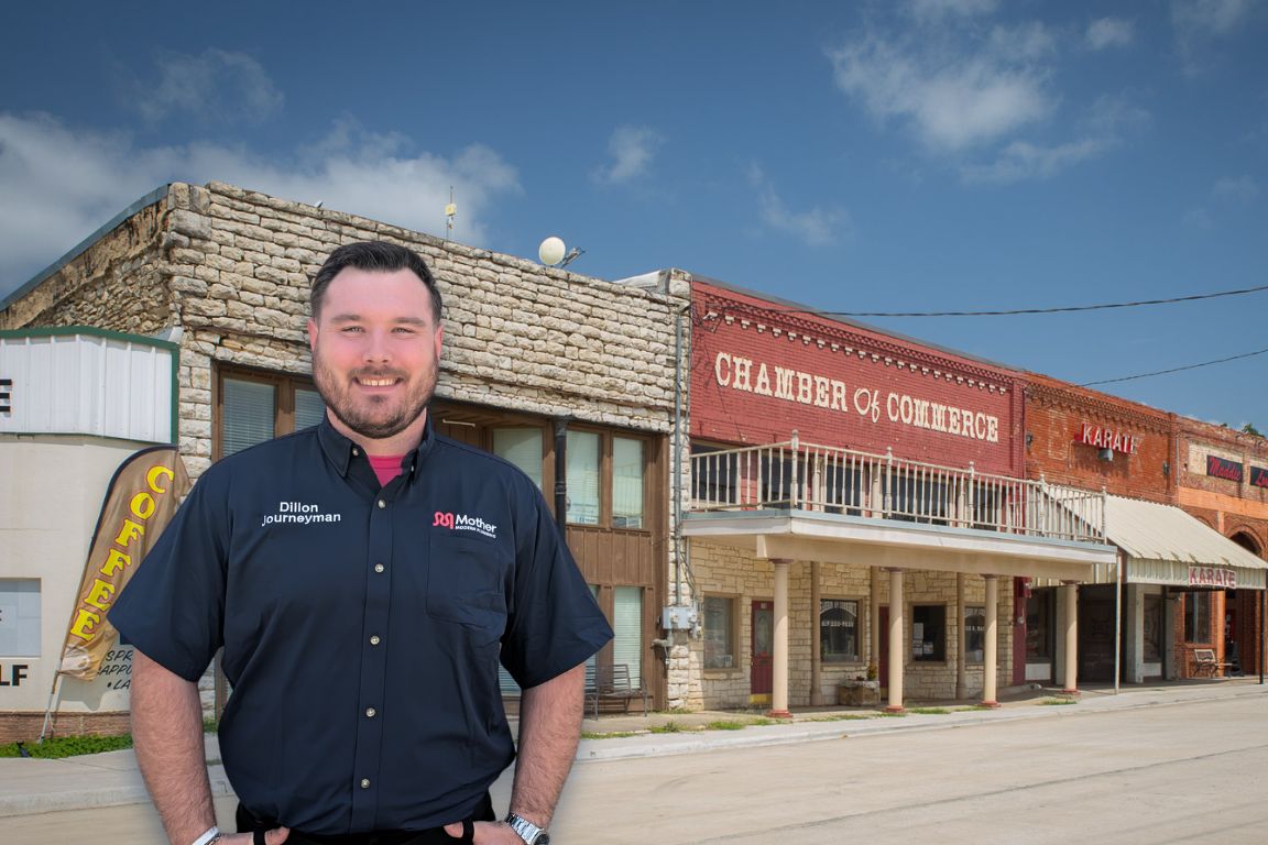 Photo of a uniformed plumber in Springtown, TX from Mother Modern Plumbing standing and smiling