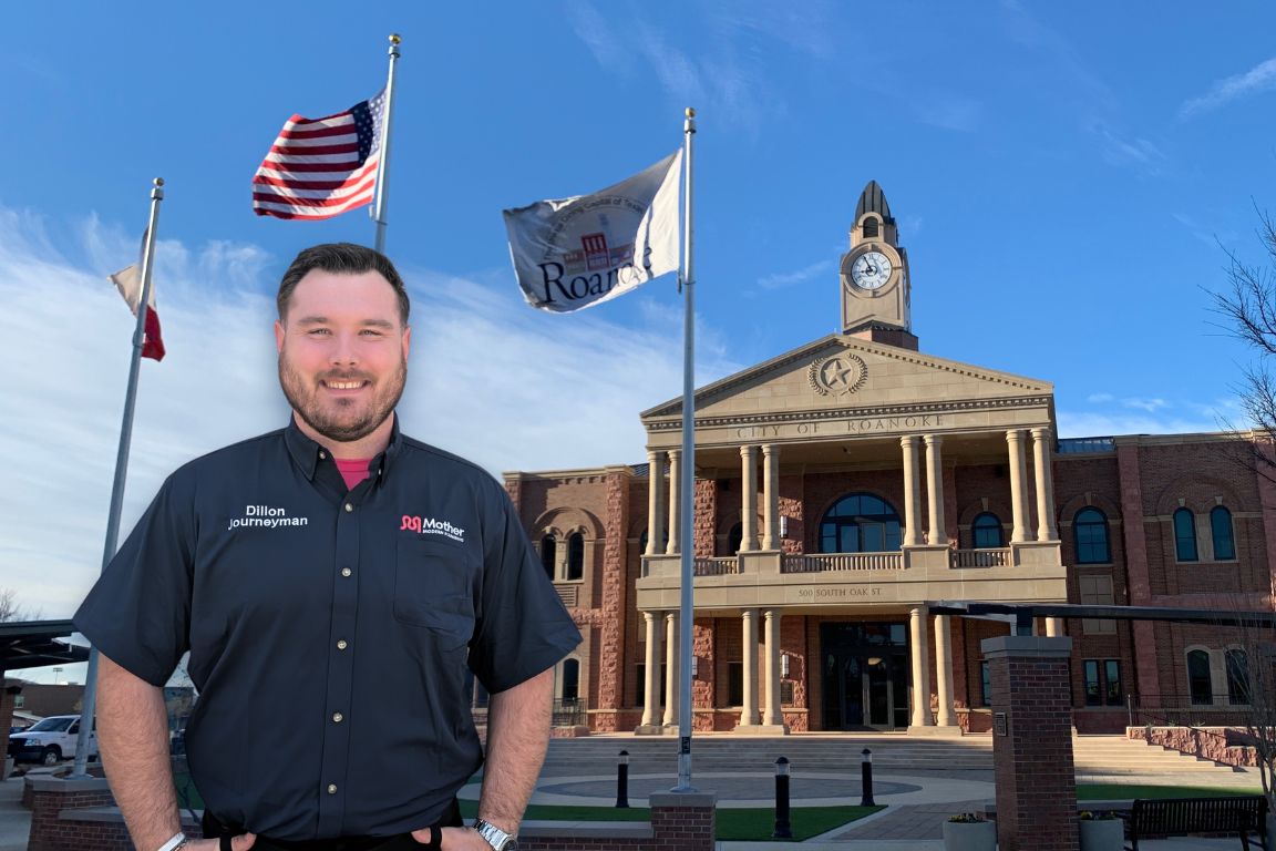 Photo of a uniformed plumber in Roanoke, TX from Mother Modern Plumbing standing and smiling